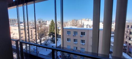 a view of a city from a building with windows at Extra Apartman Palata in Banja Luka