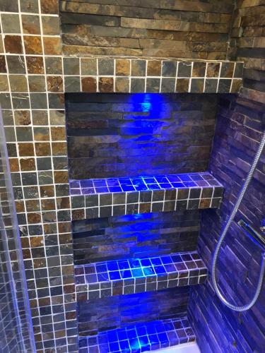 a bathroom with blue glass tiles on the wall at B-happy Apartments in Vilnius