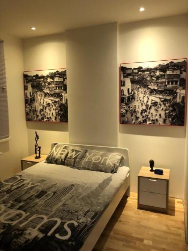 a bedroom with two pictures on the wall and a bed at B-happy Apartments in Vilnius