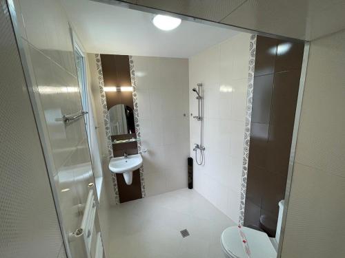 a bathroom with a shower and a toilet and a sink at Къща за гости Деметра in Velingrad