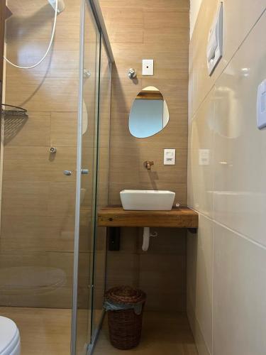 a bathroom with a sink and a glass shower at Suíte da Alê in Marau