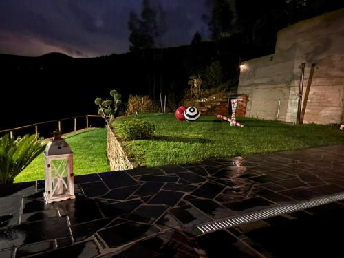 een tuin 's nachts met een lantaarn op het gras bij Casinha Serabigoes Arouca Passadiços Paiva in Arouca
