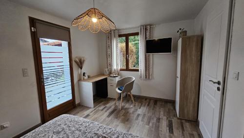 a bedroom with a bed and a desk and a chandelier at Chambre privé climatisé in Vertaizon