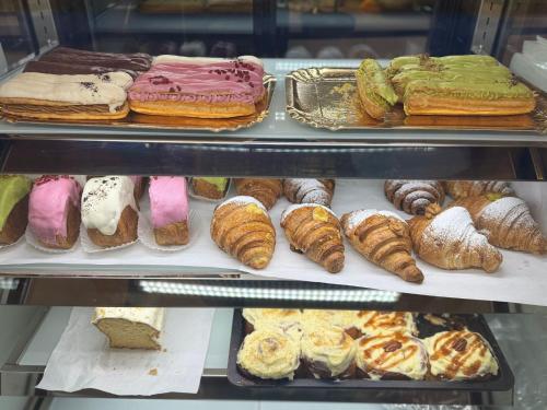 una vitrina llena de diferentes tipos de repostería en La Storia Guest House, en Piteşti