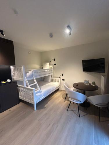 a bedroom with a bunk bed and a table and chairs at Manteka Logies in Ieper