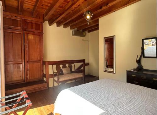 a bedroom with a bed and a dresser and a chair at Departamento centrico in Durango