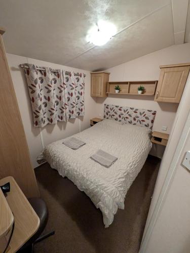 a small bedroom with a bed in a small room at Stay static Hayling island holiday park in South Hayling