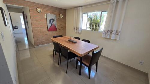 ブルマジーニョにあるCasa de Nair Pousadaの木製のテーブルと椅子のあるダイニングルーム