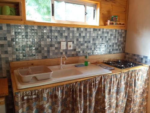 a kitchen counter with a sink and a stove at Chalets rustiques en pleine nature, L'ARCHIPEL in Punta Del Diablo
