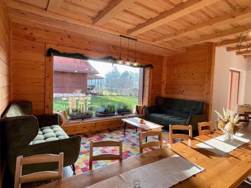 Una sala de estar con una mesa y una gran ventana. en Holiday Home Holiday Raj, en Bešeňová