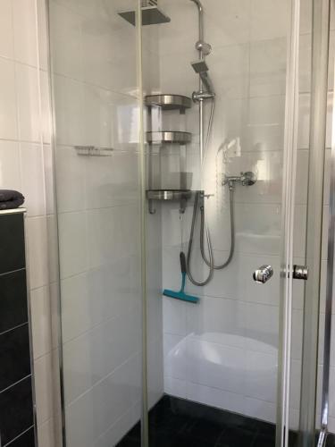 a shower with a glass door in a bathroom at Zomerhuis Zwart in Egmond aan Zee