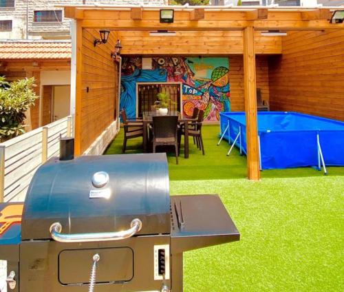 a backyard with a bbq on the grass at toptop in Majdal Shams