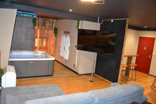 a living room with a tub and a couch at La Parenthèse SPA in Arc