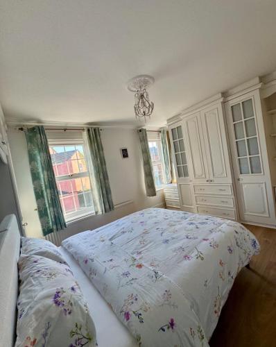 a bedroom with a bed and two windows at Three Bees in Hythe