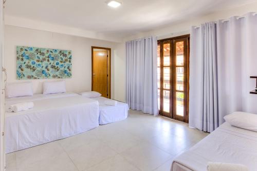 Village do Bosque - Rede Tonziro في بورتو سيغورو: غرفة بيضاء بسريرين ونافذة