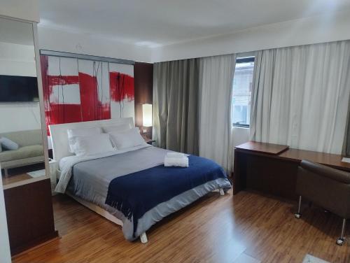 a hotel room with a bed and a desk at Hotel Meliá Ibirapuera Grandflats Suíte Master Luxo in Sao Paulo