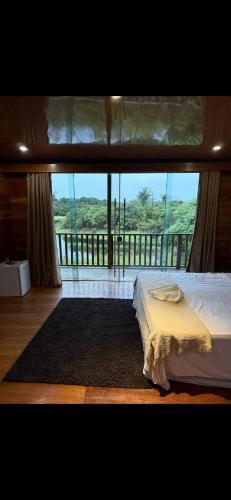 马瑙斯Amazon Tucuna Resort的一间卧室设有一张床,享有阳台的景色