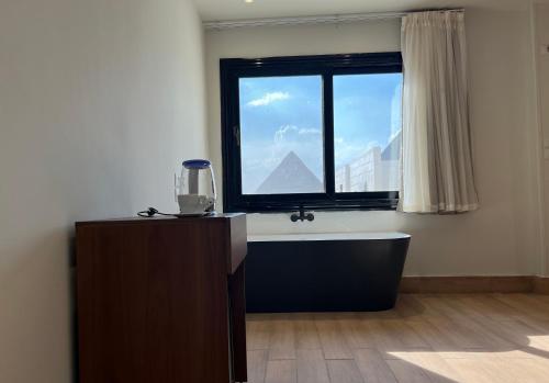 a bathroom with a bath tub and a window at King's Gate pyramids & sphinx view hotel in Cairo