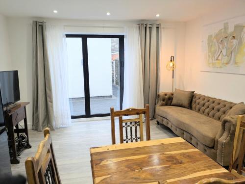 a living room with a couch and a table at 2 bedroom house with yard in Cardiff