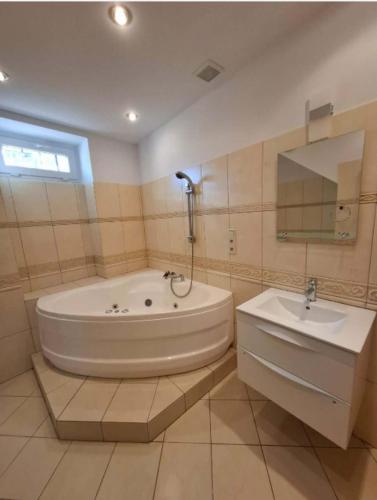 a large bathroom with a tub and a sink at Apartament Juliusz Slowacki in Szczawno-Zdrój