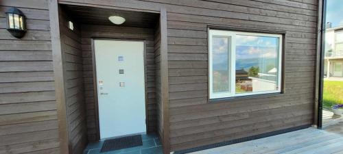 a wooden house with a door and a window at Bardufoss Panorama in Bardufoss