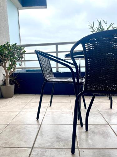 a black chair sitting next to a table at Departamento arriendo remodelado in Viña del Mar
