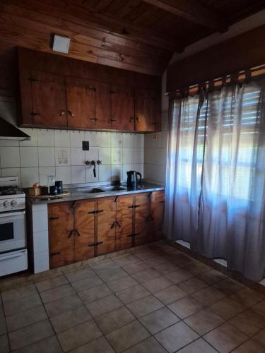 a kitchen with wooden cabinets and a stove top oven at La Casa De Yayo in San Luis