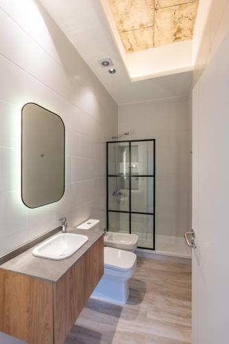 a bathroom with a sink and a toilet at Araucarias Apartamentos in Moreno