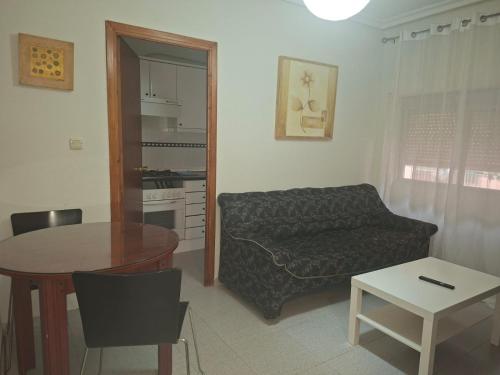 una sala de estar con un sofá y una mesa en Confortable piso en Puertollano, en Puertollano