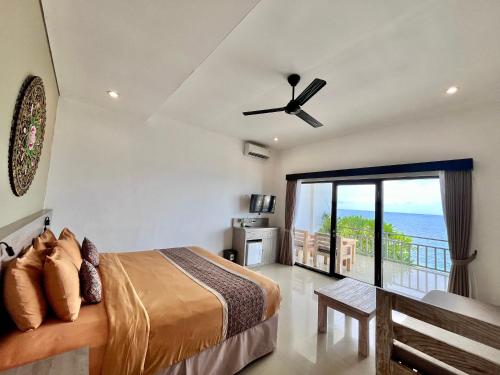 アメッドにあるMejore Beach Hotelのベッドルーム1室(ベッド1台付)、海を望むバルコニーが備わります。