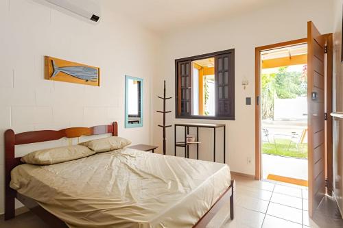 a bedroom with a large bed and a window at Casinhas Terõ - in Boracéia