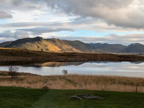 a large body of water with a mountain in the background at Lauvåsstua-Charming house by the sea in Bøstad