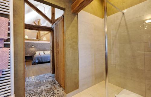 a glass shower in a bathroom with a bedroom at La villa des Chouettes in Maisons-lès-Chaource