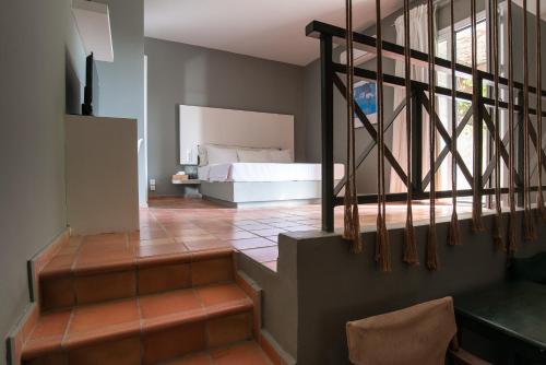 een slaapkamer met een bed en een trap met een bed bij Mounda Beach Retreat in Skála Kefalonias