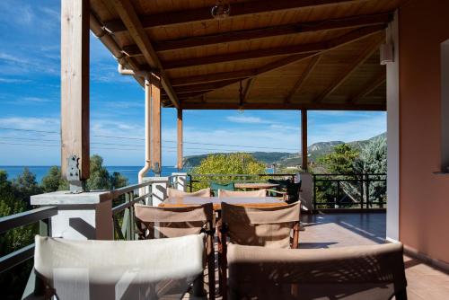 un tavolo e sedie su un balcone con vista sull'oceano di Mounda Beach Retreat a Skala di Cefalonia