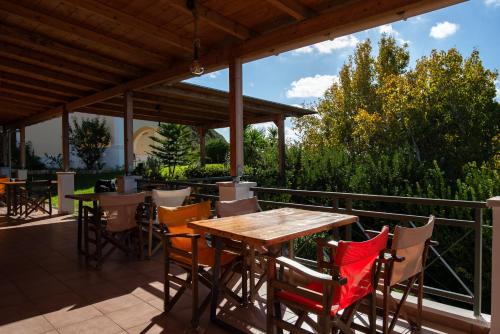 un tavolo e sedie in legno su un patio di Mounda Beach Retreat a Skala di Cefalonia