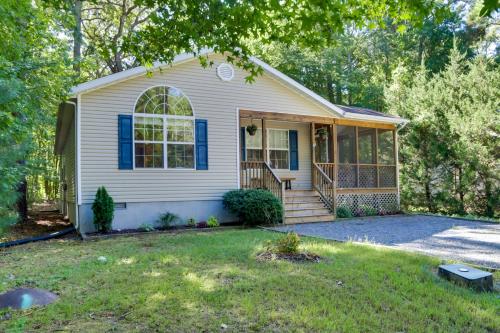 a small white house with a porch at Pool, Trail Access! Dog-Friendly Ocean Pines Haven in Ocean Pines