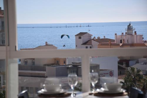 a view of the ocean from a balcony with wine glasses at Carabela-C704 in Torrox Costa