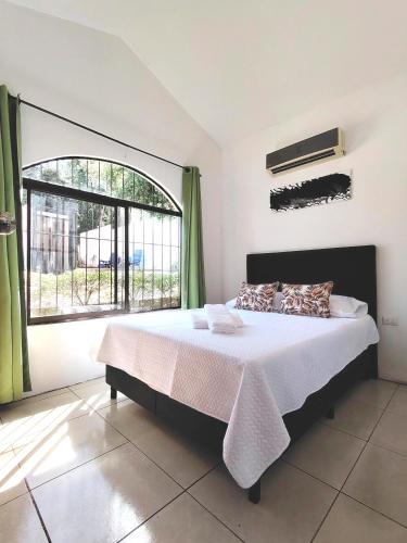a bedroom with a bed and a large window at Casa Chika, Playa Grande, Private House, Pool, Kitchen, AC in Cuajiniquil