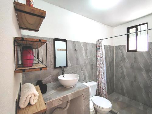 a bathroom with a toilet and a sink and mirror at Casa Chika, Playa Grande, Private House, Pool, Kitchen, AC in Cuajiniquil