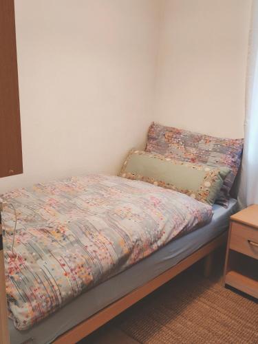 a bedroom with a bed with a floral comforter at Pfeiren Leukerbad in Leukerbad