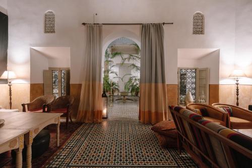 a room with an archway with chairs and a table at Dar Lalla F'dila in Marrakesh