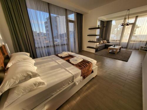 a bedroom with a large bed and a large window at Hotel SABA in Kobuleti