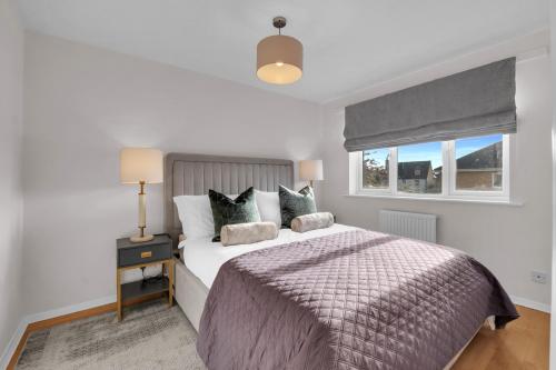 a bedroom with a large bed and a window at Modern 3 BR House near Bicester Village in Bicester