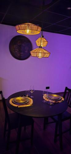 a dining room table with plates and glasses and lights at Instant Evasion in Châtelet