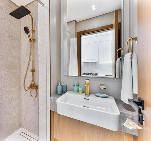 a bathroom with a white sink and a mirror at 15 min from Dubai Marina & JBR beach Studio apartment AZURE BINGHATTI JVC in Dubai