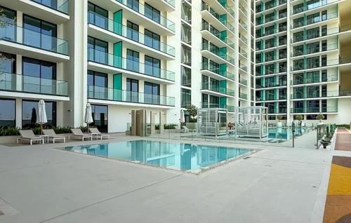 a large apartment building with a pool in front of it at 15 min from Dubai Marina & JBR beach Studio apartment AZURE BINGHATTI JVC in Dubai