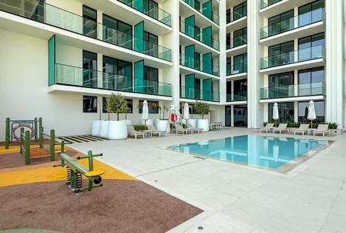 a large building with a swimming pool in front of it at 15 min from Dubai Marina & JBR beach Studio apartment AZURE BINGHATTI JVC in Dubai