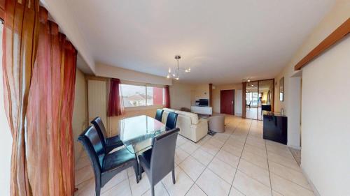 ein Wohnzimmer mit einem Glastisch und Stühlen in der Unterkunft Djimmy hébergement in Saint-Herblain