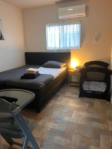 a bedroom with two beds and a chair in it at Apartments & Wellness Diva Turtle in Sint Jozefsdal
